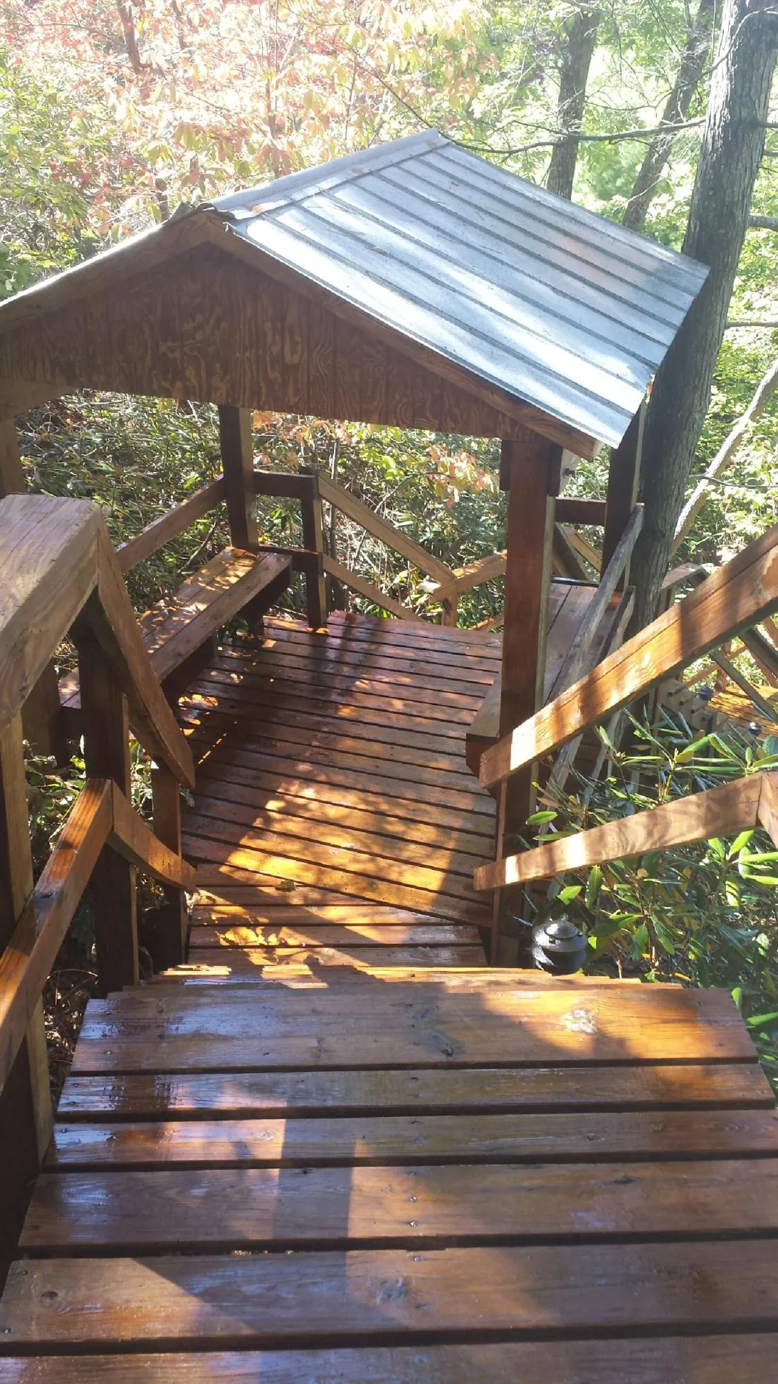 Freshly stained wood walkway and covered shelter with a metal roof in Carbon Cliff