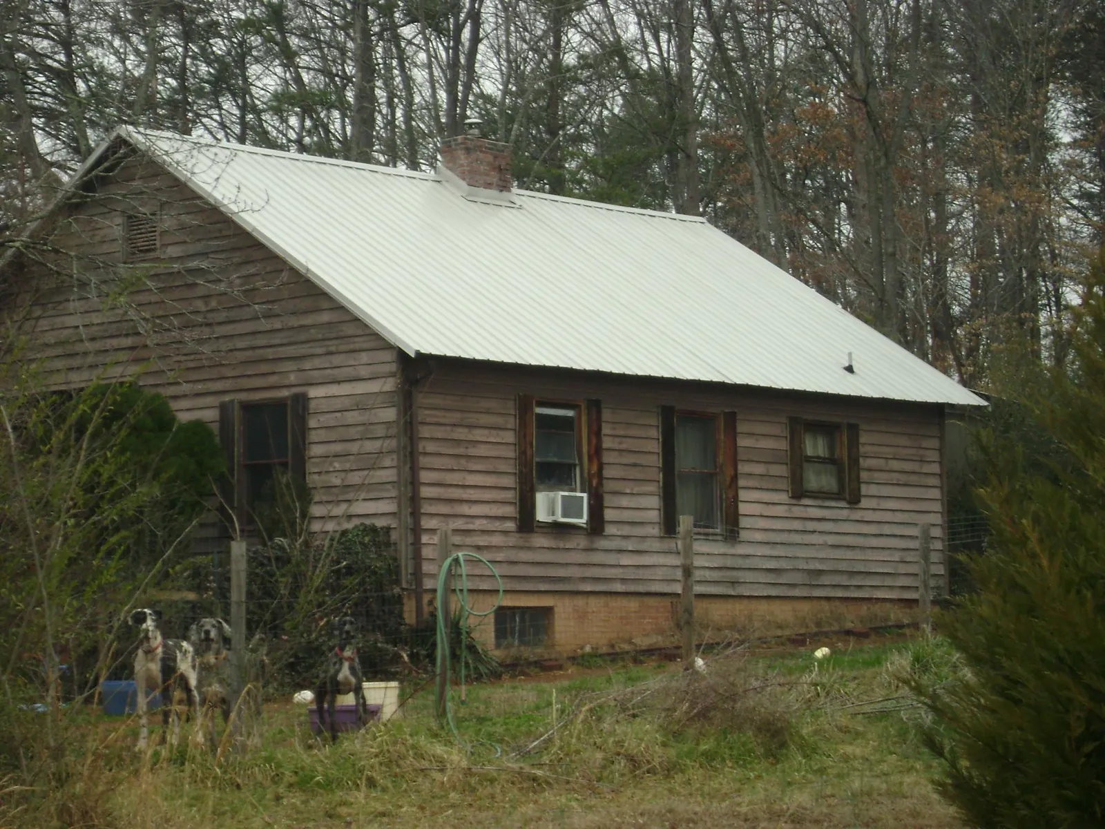 White metal roof on an old wood sided farmhouse, from a Metal Roof Installation job in Carbon Cliff